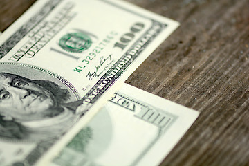 Image showing Close-up of a $100 banknotes on wooden background