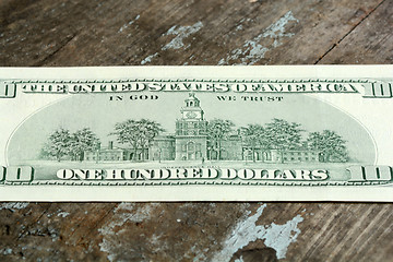 Image showing Close-up of a $100 banknotes on wooden background