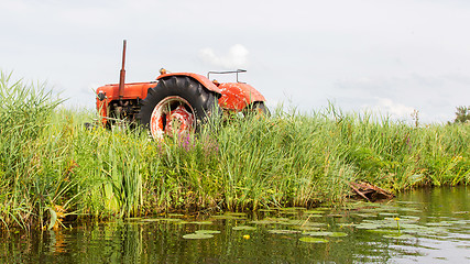 Image showing Farmers pumping water with old tractor