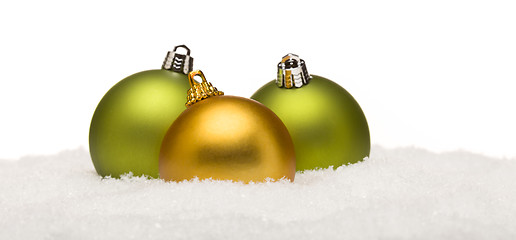 Image showing Green and Yellow Christmas Ornaments on Snow Isolated on White