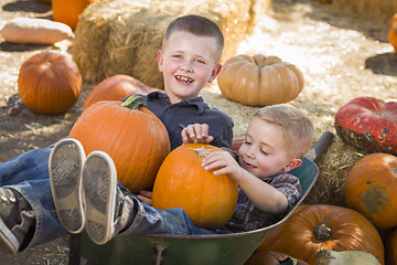 Image showing Two Little Boys Playing in Wheelbarrow at the Pumpkin Patch