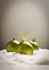 Image showing Green Christmas Ornaments on Snow Over a Grey Background