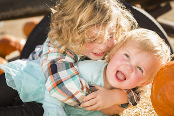 Image showing Little Boy Playing with His Baby Sister at Pumpkin Patch
