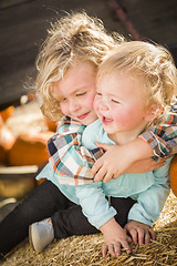 Image showing Little Boy Playing with His Baby Sister at Pumpkin Patch