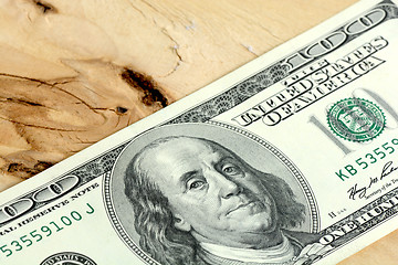 Image showing One hundred dollars banknotes on wooden background