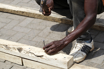 Image showing African carpenter works with wood