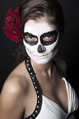 Image showing Woman with makeup of la Santa Muerte with red roses in front of 