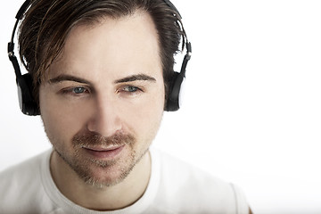 Image showing Attractive man with headphones in front of a white background en