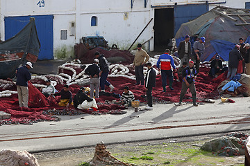 Image showing Fishermen repair nets