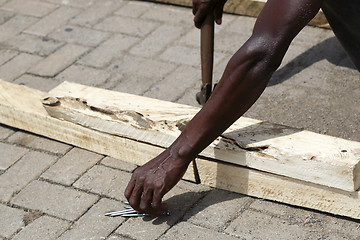 Image showing African carpenter works with wood