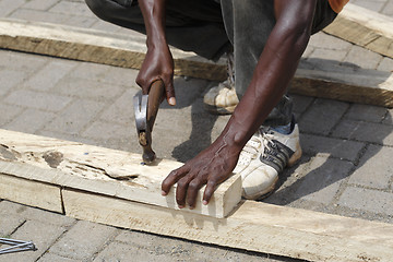 Image showing African carpenter works with wood