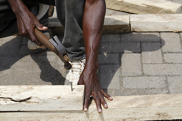 Image showing African carpenter works with wood