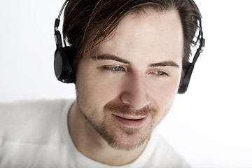 Image showing Attractive man with headphones in front of a white background en