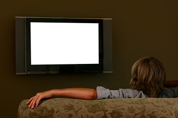 Image showing boy sitting on couch watching widescreen television