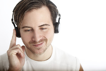 Image showing Attractive man with headphones in front of a white background en