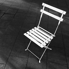 Image showing White foldable chair on dark background