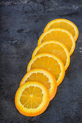 Image showing Orange slices arranged on a dark background