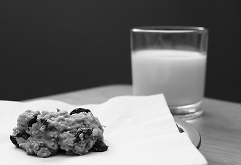 Image showing Freshly baked oatmeal raisin cookie with a glass of milk