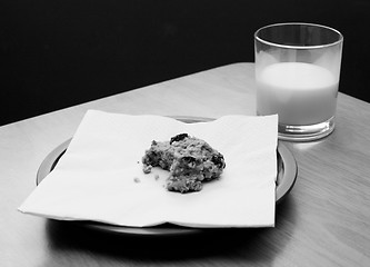 Image showing Half-eaten cookie with a half drunk glass of milk