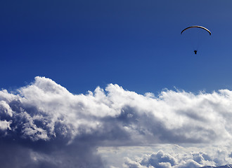 Image showing Silhouette of paraglider and blue sunny sky