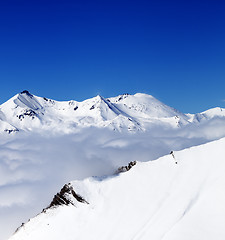 Image showing Mountains in clouds at nice day. View from ski slope.