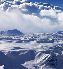 Image showing Snowy sunlight plateau and sky with clouds