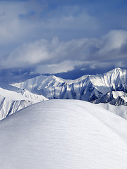 Image showing Top of off piste snowy slope and cloudy mountains