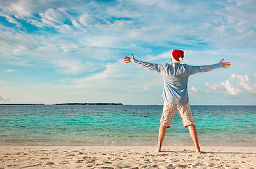 Image showing Man in santa hat on the tropical beach