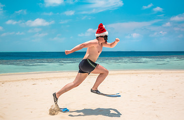 Image showing Man in santa hat on the tropical beach