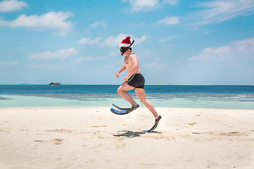 Image showing Man in santa hat on the tropical beach