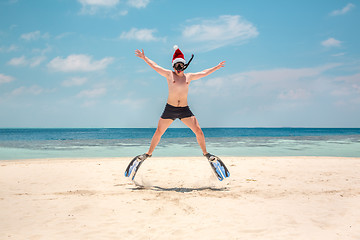 Image showing Man in santa hat on the tropical beach