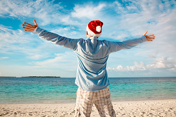 Image showing Man in santa hat on the tropical beach