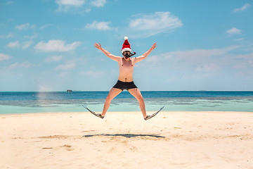 Image showing Man in santa hat on the tropical beach