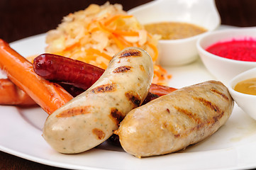 Image showing German sausage with cabbage and sauces