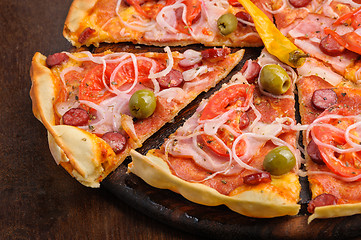 Image showing Pizza with tomato, salami, peppeeoni, olives and yellow hot pepper