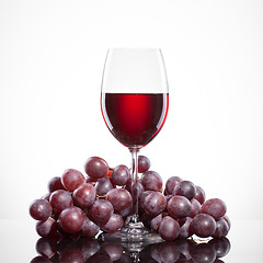 Image showing Glass of red wine and grape isolated on white