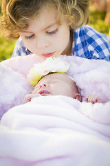 Image showing Young Boy Gazing at His Newborn Baby Girl Sister