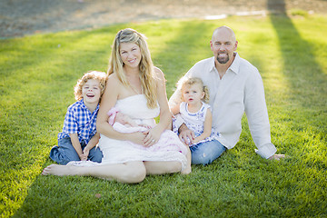 Image showing Beautiful Young Family Portrait Outside on Grass