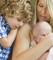 Image showing Young Mother Holds Newborn Baby Girl as Brother Looks On