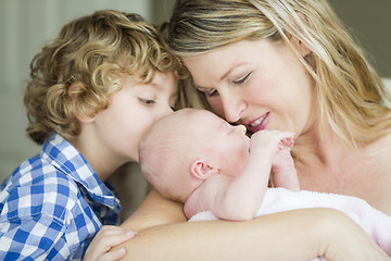 Image showing Young Mother Holds Newborn Baby Girl as Brother Looks On