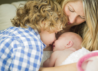 Image showing Young Mother Holds Newborn Baby Girl as Brother Looks On