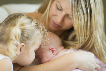 Image showing Young Mother Holds Newborn Baby Girl with Young Sister