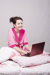 Image showing The girl sat in bed with a laptop