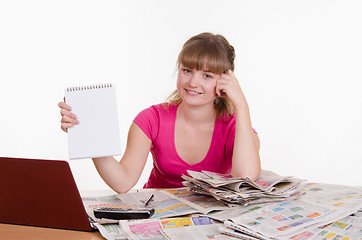 Image showing Girl shows record on a notepad while sitting at table