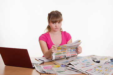 Image showing The girl has not found an ad in the newspaper