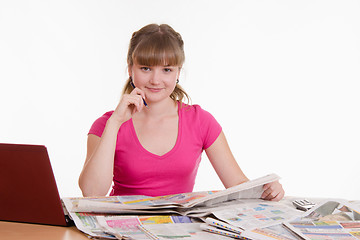 Image showing Girl reading a newspaper ad