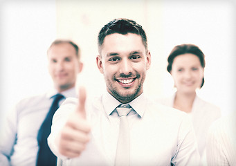 Image showing businessman in office showign thumbs up