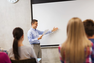 Image showing group of students and smiling teacher with notepad