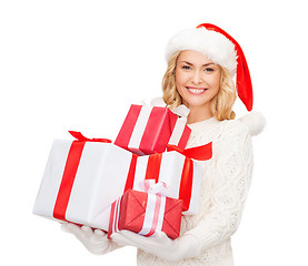 Image showing woman in santa helper hat with many gift boxes