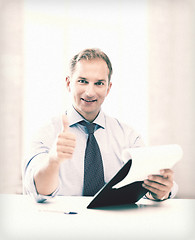 Image showing businessman with papers showing thumbs up